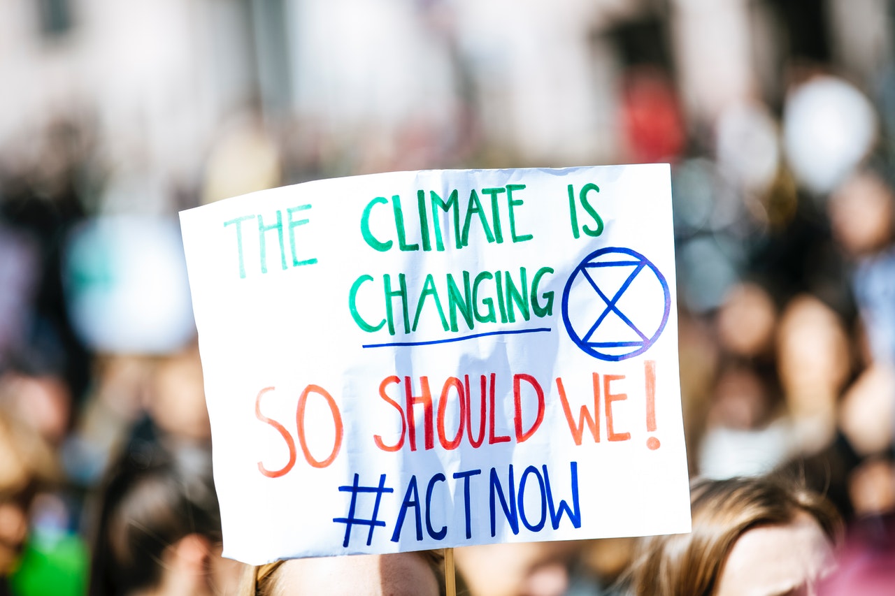 שלט בהפגנה "THE CLIMATE IS CHANGING SO SHOULD WE! #ACT NOW"