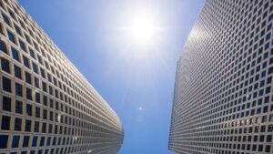 The sun shines brightly in the Tel Aviv sky by the Azrielli towers