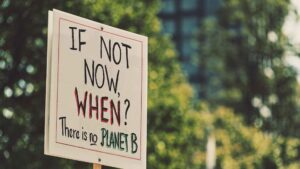 A sign reading "If not now, when? There is no Planet B"