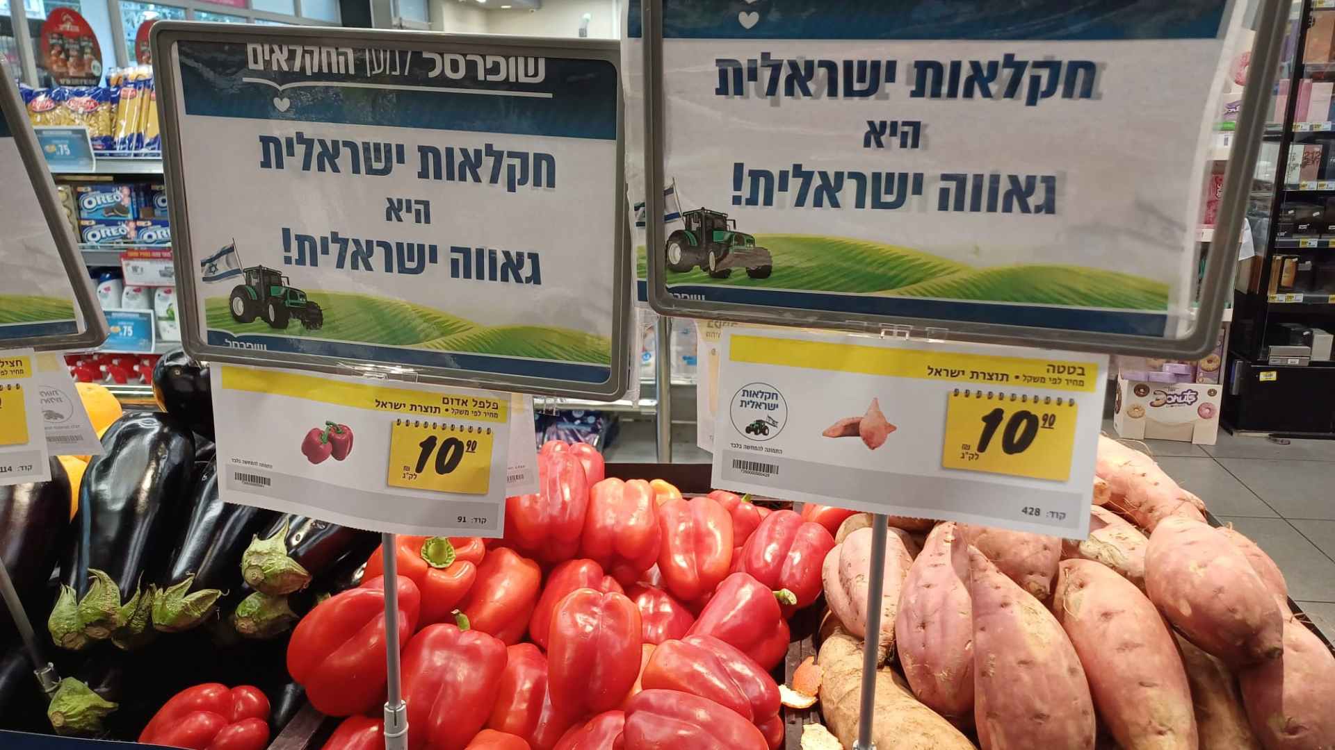 A supermarket sign over fresh produce saying 'Israeli agriculture is Israeli pride!'